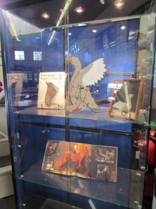Contents of the display cabinet containing the Goose Puppet, Handspring puppet book and the program from the play